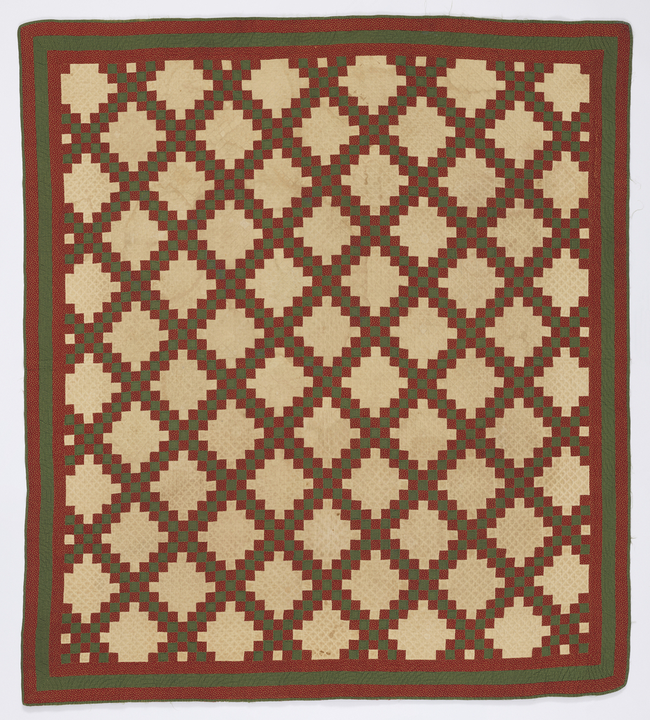 Image features: Patchwork quilt with a stepped squared diamond pattern in ivory, red and green. The ivory fabric forming the stepped diamond is plain. The red and green fabrics forming the lattice and borders are patterned by tiny flowers. The back is red with green edge. Please scroll down to read the blog post about this object.