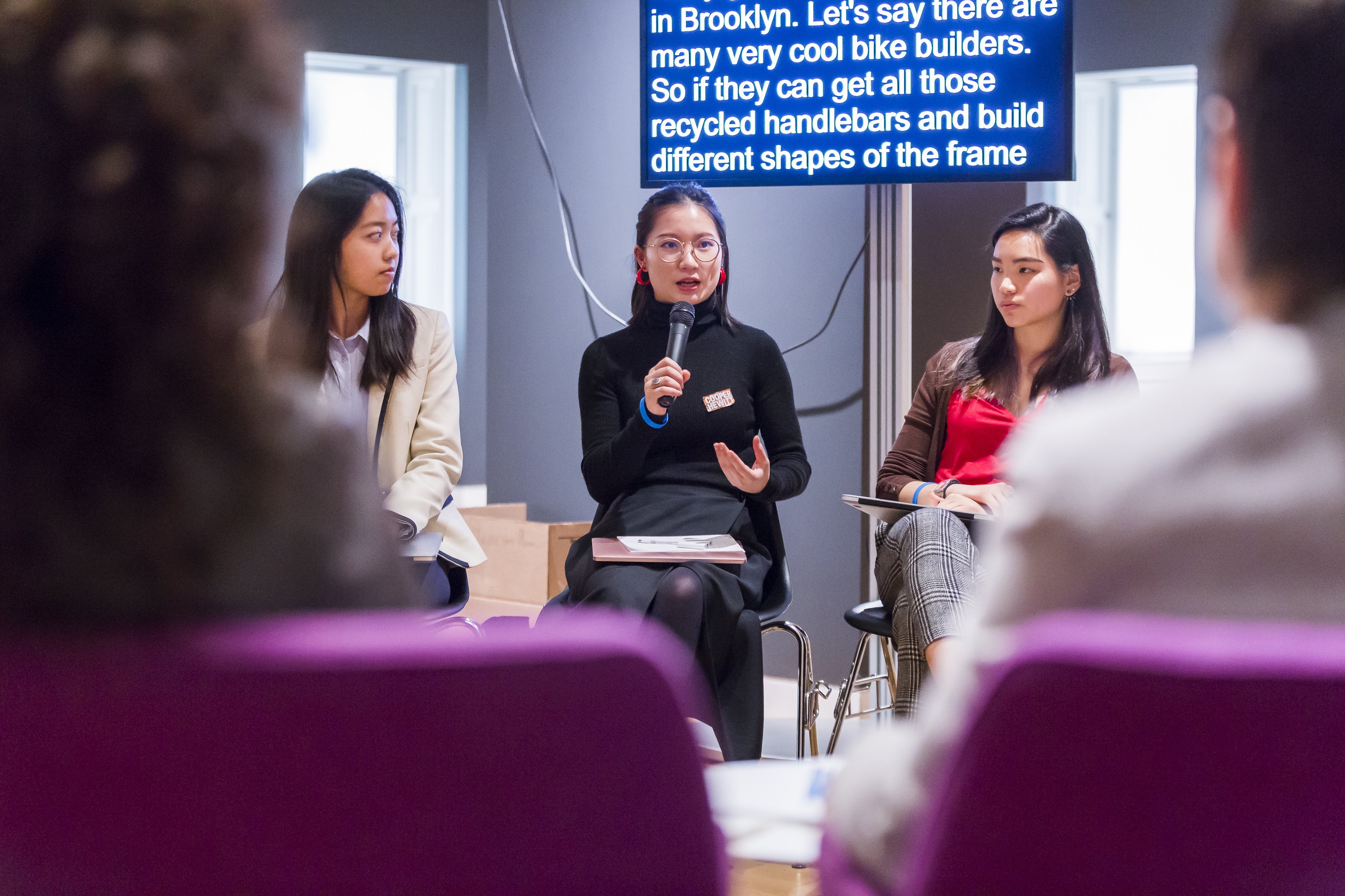 Image of panel discussion from Access + Ability symposium, a female student presents her design ideas.