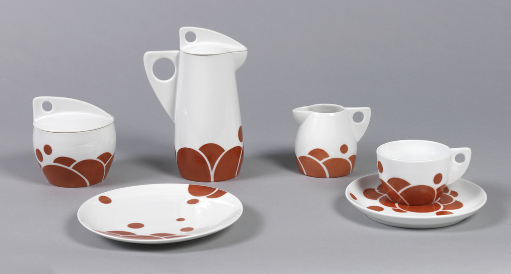 Image features a five part coffee service. The surfaces and forms of this set are based on the circle, from the rust-red surface decoration to the cutouts in the handles and lids of the vessels. Please scroll down to read the blog post about this object.