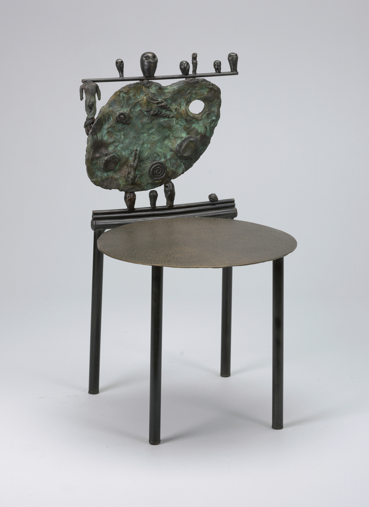 Cast bronze side chair composed of flat disk seat on four straight cylindrical legs; back composed of cast bronze painter’s palette decorated with spirals; "crest rail" consisting of a horizontal rod, a headless figure below the rod, to left of palette, and six different sized heads sitting on the rod; three cast bronze heads situated between the seat and back, supporting the back, with a fourth head to the right. Please scroll down to read the blog post about this object.