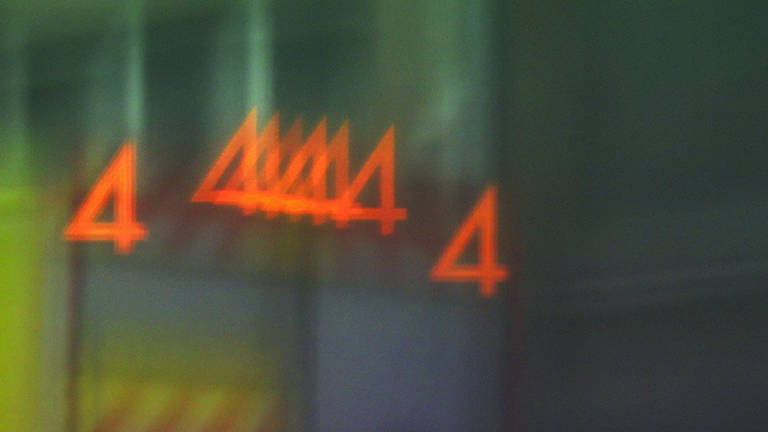 a still image from Synesthetic Calculus, a 2012 film by David Genco. The number 4 in orange is repeated against a muted, multicolored abstract background.