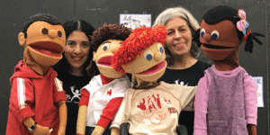 Morning at the Museum program information. Image of four puppets representing diverse races, abilities, and genders, with two puppeteers. All face camera smiling. Scroll down for activity information.