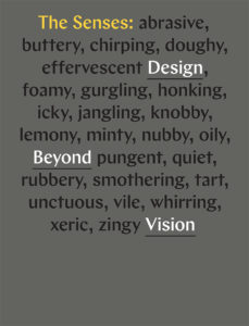 The cover of the exhibition book with a list of words describing sensory experiences, such as lemony, rubbery, icky, etc., against a dark grey background.