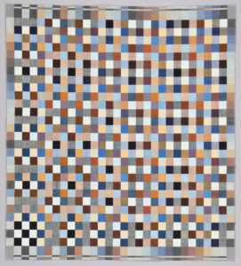 A cotton textile woven in an abstract geometric pattern comprised of a multitude of small squares forming one large square. Colors include black, greys, orange, reds, blues, browns, pinks, and whites.