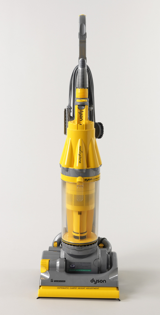 Image features upright vacuum cleaner with yellow, gray and clear plastic cylindrical body. Please scroll down to read the blog post about this object.