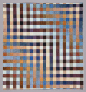 A mercerized cotton, double-weave textile with an abstract geometric design of alternating light and dark squares that created a sense of depth and movement. Colors include orange, blues, purples, and browns.