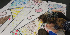 Title: Fun with Wallpaper at Industry City. Photograph of children drawing on an oversized wallpaper. Scroll down for more information.