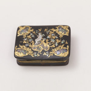 Image features a rectangular snuffbox with hinged lid decorated with inlaid mother-of-pearl fragments arranged to depict Cupid with small wings and holding a golden arrow, amid chased and inlaid gold scrollwork and grapevines. Please scroll down to read the blog post about this object.