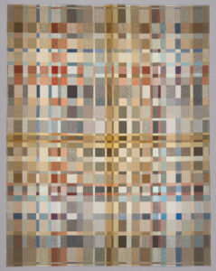 A small, nearly square weaving with an abstract geometric composition in four parts in shades of tan, red, and blue, divided by a cross in ochre.