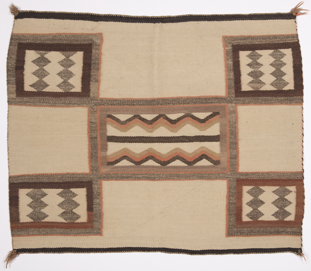 Image features: Off-white blanket with five rectangles of geometric pattern: Four corners are gray diamonds on an off-white ground surrounded by concentric squares of brown, gray and peach. Center is brown, peach and tan zigzags bands with border of gray and peach concentric squares. Please scroll down to read the blog post about this object.