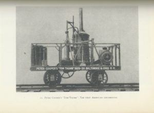 This image is a scan from a book. The page features an image of a locomotive vehicle on tracks. Four prominent wheels support a fenced-in platform that houses shovels and various pieces of machinery. Wording on the platform reads "Peter Cooper's 'Tom Thumb' 1829–30 Baltimore & Ohio R. R." Text directly below this image reads "13. Peter Cooper's 'Tom Thumb': The First American Locomotive".