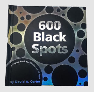 Image features black circles on a silver background with title