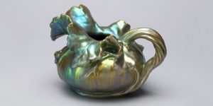 Leaf Pitcher, designed by Lajos Mack, ca. 1901. Squat gourd form with leaf shaped spout and gourd stem handle with green and gold iridescent luster finish. Scroll down for information about an exhibition of Iridescent design