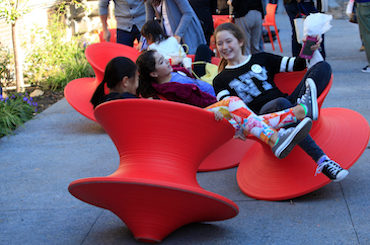 Teen girls play on the Spun Chairs in the garden.