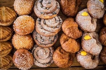 Several rows of pastries and donuts.