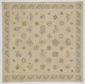 Image features: Patches embroidered with flowers and 'japonaise' patterns all in the same grey/blue thread on muslin foundation. The date 1900 is embroidered in the center and there is a repeating border around the edges. The outline the embroidery patterns is visible under the motifs. Backed with white cotton, quilted in straight lines. Please scroll down to read the blog post about this object.