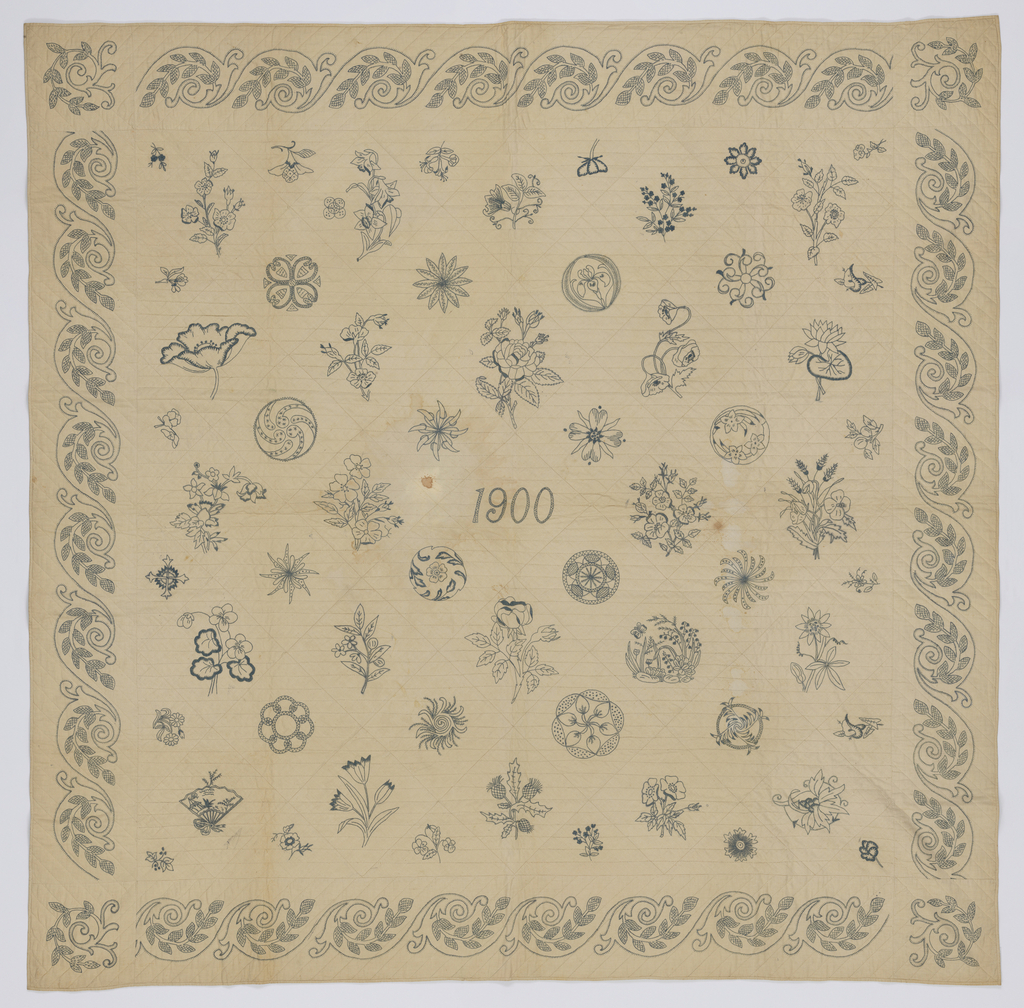 Image features: Patches embroidered with flowers and 'japonaise' patterns all in the same grey/blue thread on muslin foundation. The date 1900 is embroidered in the center and there is a repeating border around the edges. The outline the embroidery patterns is visible under the motifs. Backed with white cotton, quilted in straight lines. Please scroll down to read the blog post about this object.