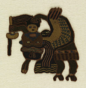 Flying or floating masked human figure holding a wand or a fan and a trophy head. Embroidered in strong colors.