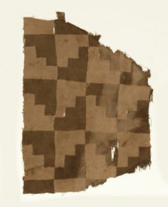 Fragment of an Andean woven cloth with a stepped pattern in pink and brown.