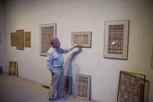 Image of Richard Landis pointing at his weavings