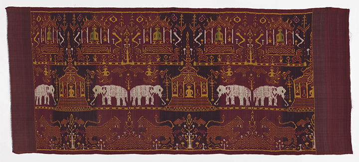 The image features a silk ikat hanging with elephants, lions, and architectural elements.