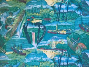 Printed cotton with scenes of Hawaii, including palm trees, volcanoes, outrigger canoes, and various resort hotels.