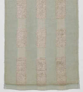 Image features a length of woven fabric with a pale green ground and vertical stripes of silver looped pile. Scroll down to read the blog post about this object.