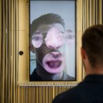 A visitor interacts with Zachary Lieberman's Expression Mirror in Cooper Hewitt's "Face Values" installation at the 2018 London Design Biennale.