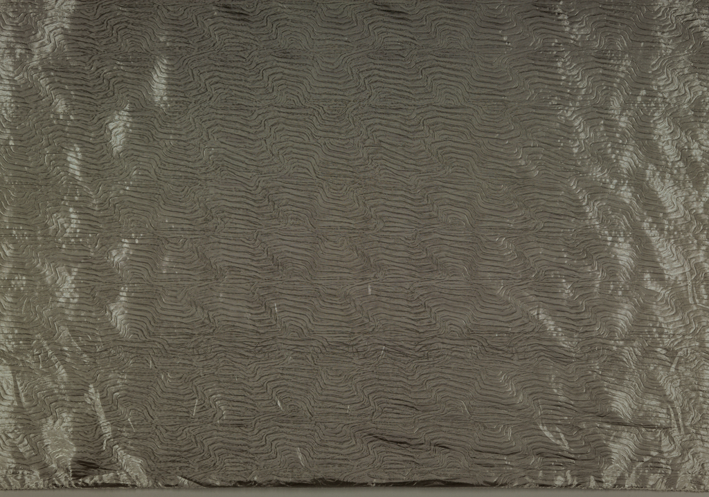 Image features: Yardage of full manufactured width, silver-colored, metallic coated plain woven polyester with wavy linear pattern from the embossing. Please scroll down to read the blog post about this object.