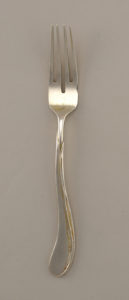 Image features a four-tined silver dessert fork, its form suggesting a tulip on its sinuous, leaf-encased stem. Please scroll down to read the blog post about this object.