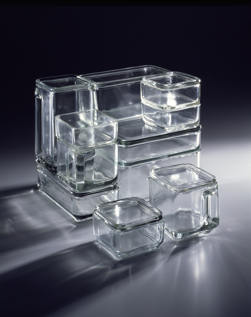 Image features set of 18 clear glass rectangular and square modular, nesting food and beverage storage containers and lids. Containers are of differing heights (about 2" to 6"), widths, and depths. Please scroll down to read the blog post about this object.