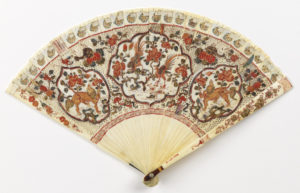 Brisé fan with ivory sticks carved à jour, decorated on obverse and reverse with birds, animals and foliage (phoenixes, dragons, and the emblems of the Chinese empress and emperor, against peonies) in red, green, blue and gilt enamel. With a tortoiseshell thumbguard and a glass stone at the rivet, threaded with leather ribbon.