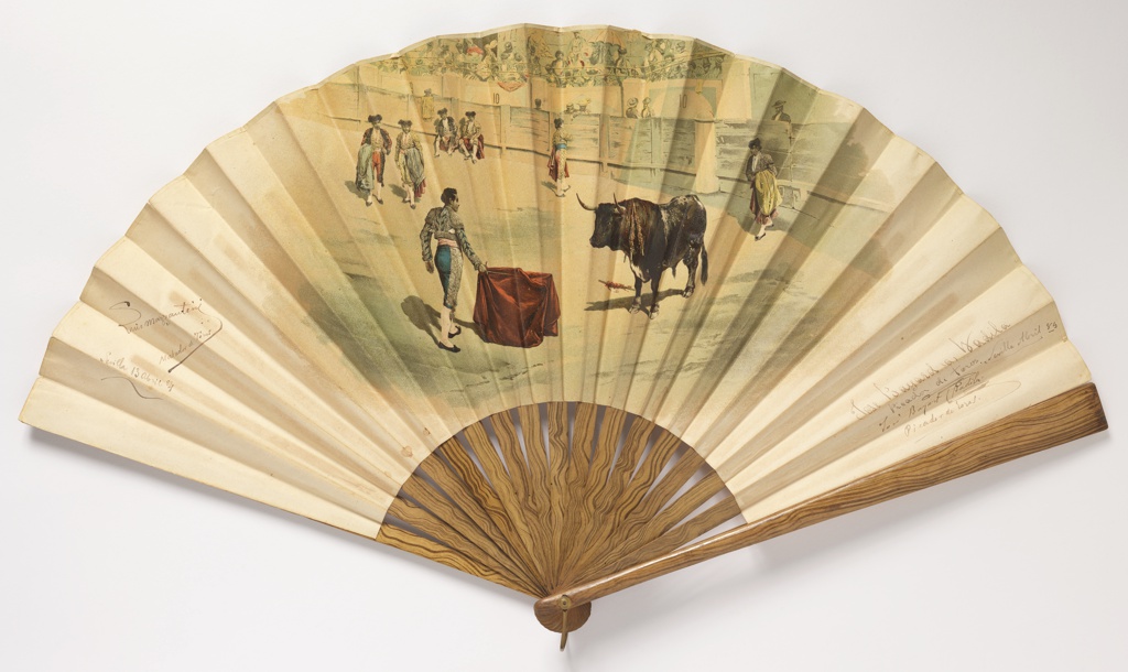 Image features: a pleated fan, paper leaf with chromolithograph showing a bullfighting scene on the obverse. Girl dancing at a cafe frequented by bullfighters on the reverse. Varnished wood sticks with painted grain. Please scroll down to read the blog post about this object.