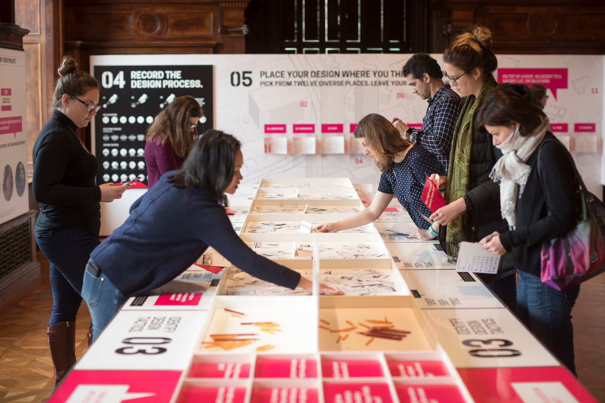 Young professional adults engage in a hands-on activity in a museum gallery.
