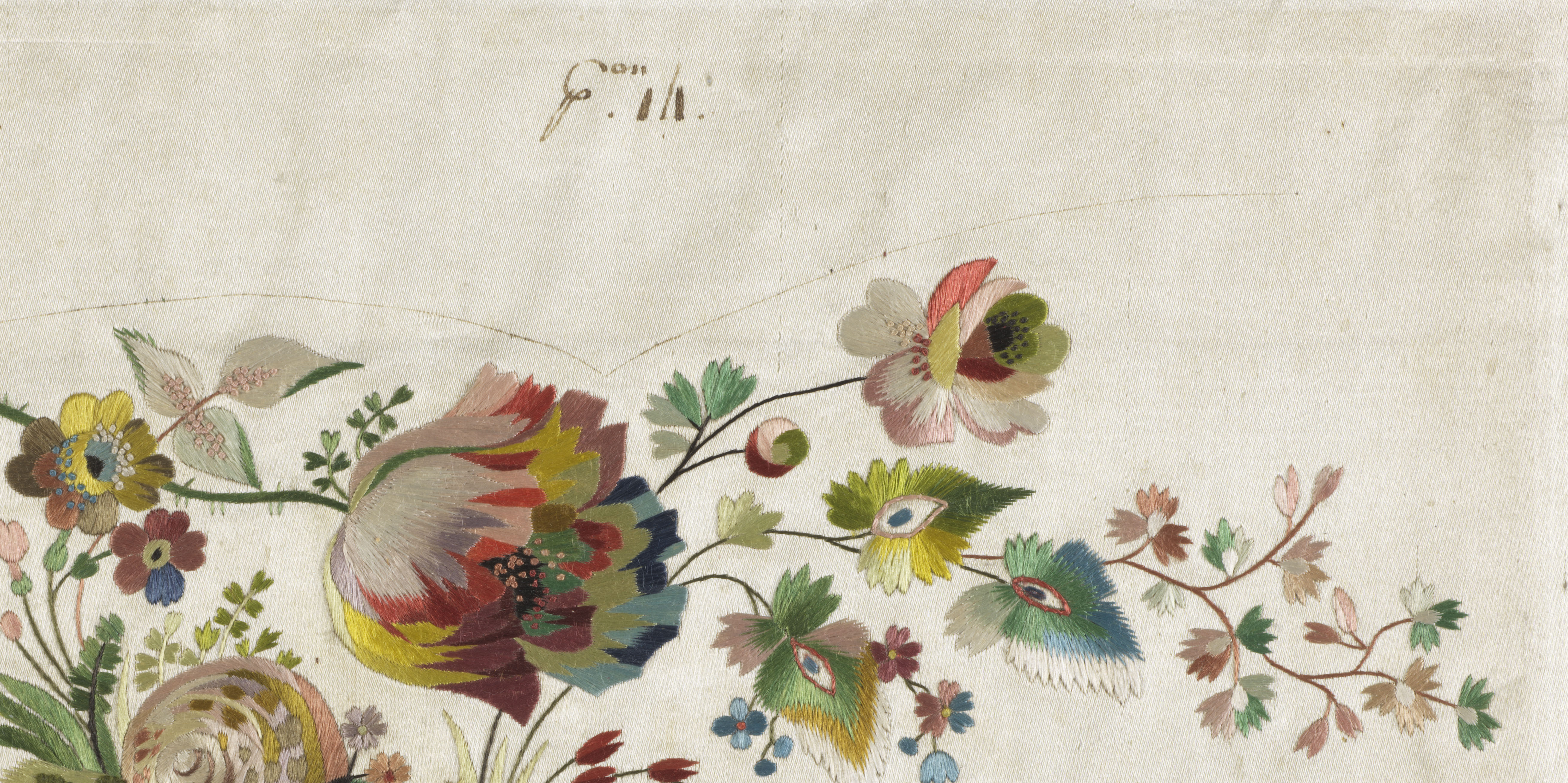 Embroidered flowers in rich warm tones on a white cloth. Flowers fill the bottom half of the image.