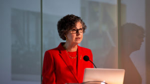 Marilyn Friedman wears a red suit, at a lecture during a design talk at Cooper Hewitt on Dec. 4, 2018