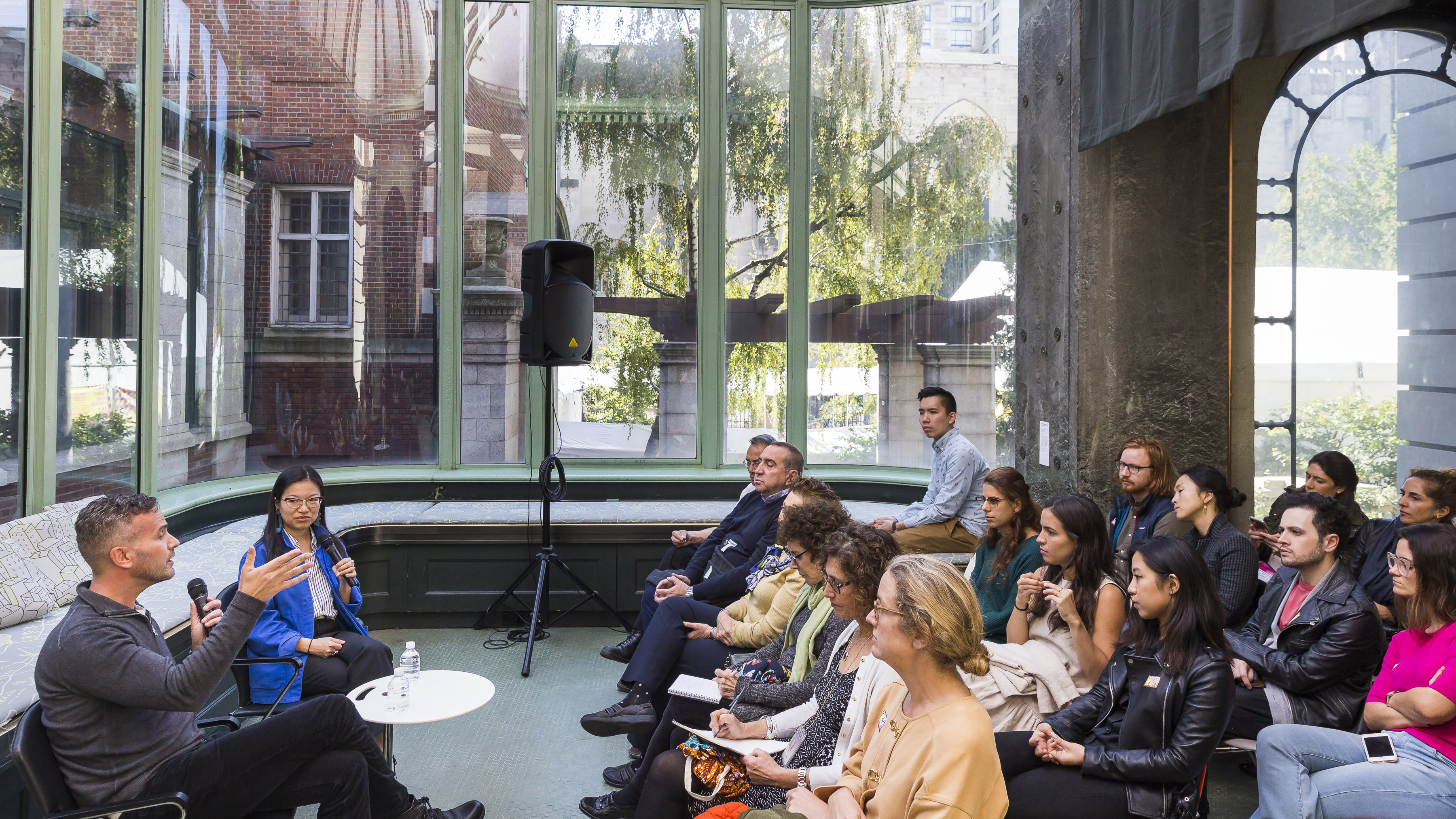 Image of Joe Doucet and Mary Ping in the conservatory of the Cooper Hewitt, talking with an audience.