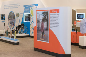 Platforms and kiosks with orange and blue backgrounds display examples of inclusive design in an installation at the World Economic Forum 2019 curated by Cooper Hewitt and presenting objects that were originally on view at the museum in the exhbition Access+Ability. Click the link below to learn more about the installation.