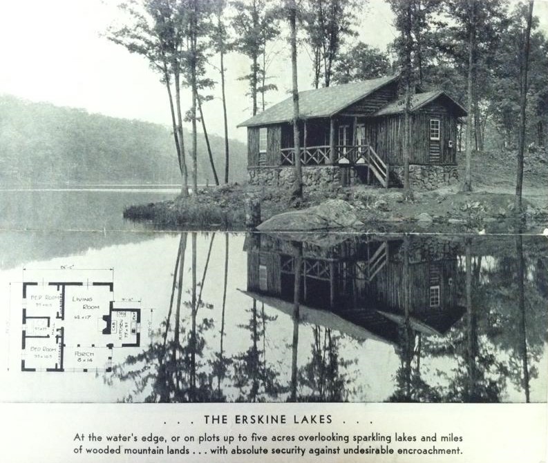 A black-and-white advertisement. The image is dominated by a photograph of a wooden cabin positioned close the the water of a lake. It is surrounded by trees, with a large hill covers in trees in the background across the lake. Superimposed on the lower left of the photograph is what appears to be the floorplan of the pictured cabin. Beneath the photograph is text that reads