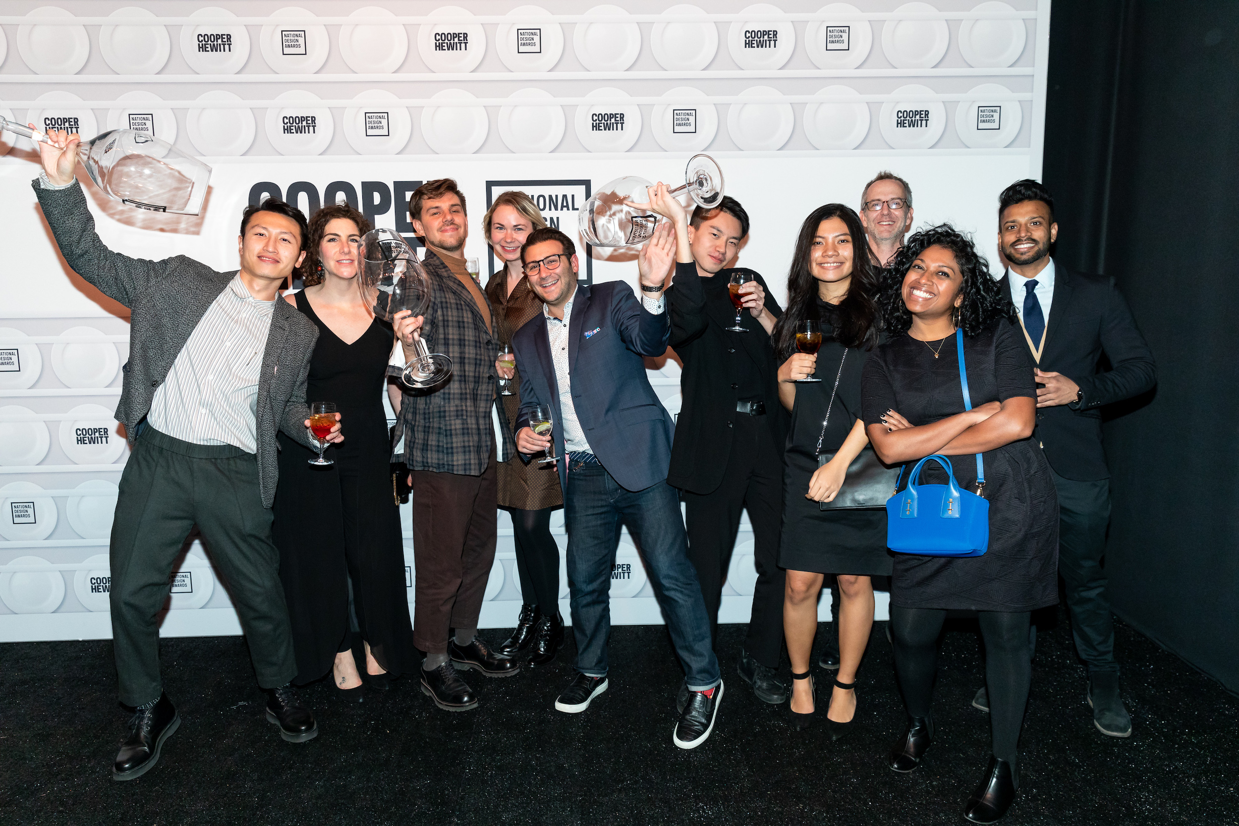 Ten people smile and pose for the camera at the National Design Awards