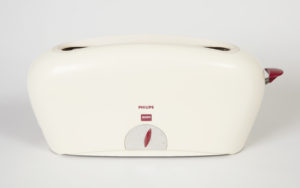 A white toaster designed with an elongated rectangular shape, curved lines, a smooth surface, and a deep red lever.