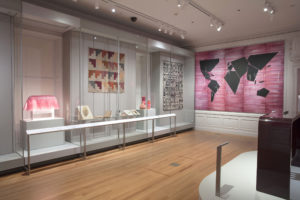 Cochineal on view at Cooper Hewitt. Pink and purple tones abound in this exhibition of design objects set in an all-white domestic interior in Carnegie Mansion. The objects on view include a pink wallpaper with continent-like black forms mounted on top, a quilt, and a lamp that looks like it's wearing a bubblegum pink wig.