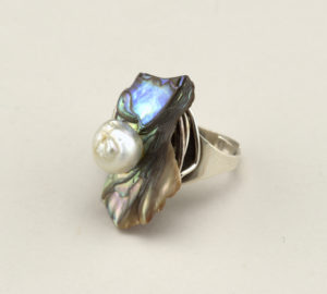 Image features a ring composed of an wide adjustable silver band featuring a large piece of iridescent abalone shell with a lustrous baroque pearl. Please scroll down to read the blog post about this object.