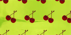 Repeating design of a pair of red cherries, connected by a stem. Printed in shades of red on a green Mylar-foil ground. The red pigments contain microencapsulated oils scented with a cherry fragrance.