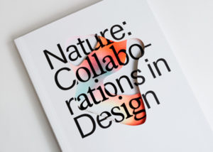 A book with a white cover. "Nature: Collaborations in Design" reads white text. The center of the book cover is die-cut to reveal an amorphous blob of green, blue, and yellow colors that all blend and blur into one another.