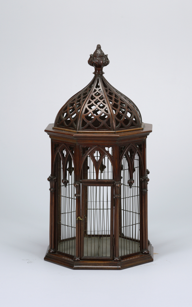 Octagonal wood and wire cage with carved decorative features