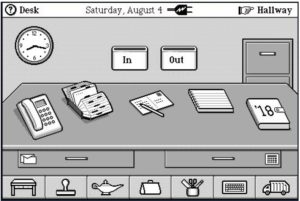 Image shows a black and white screen image of an office with clock and in and out boxes on the wall, a file cabinet, and a desktop in the foreground having a telephone, rolodex, letter, pad, and calendar.