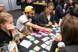 Educators sit around a table and brainstorm with post-it notes