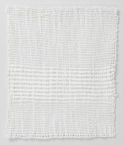 A white four-sided selvage textile loosely woven with striped pattern on the bottom half. Please scroll down to read the blog post about this object.