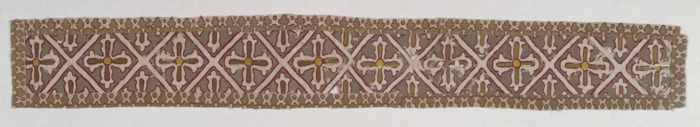 Image features a textile band with a lattice pattern having a cross in each diamond-shaped field. The lattice and crosses are white outlined with red, on a brown ground. Please scroll down to read the blog post about this object.